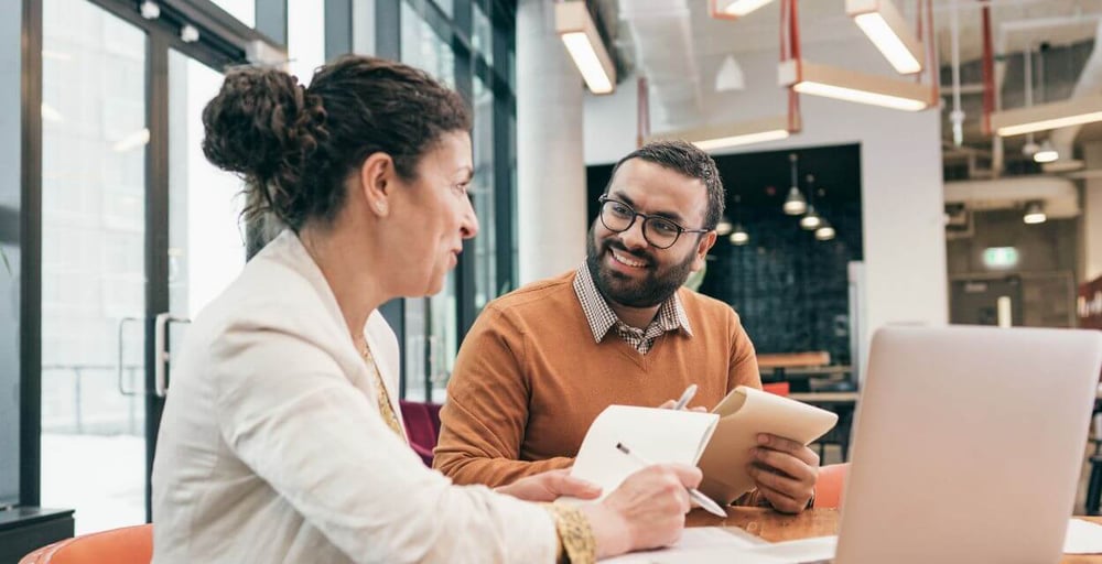 two-employees-discuss-work-blog