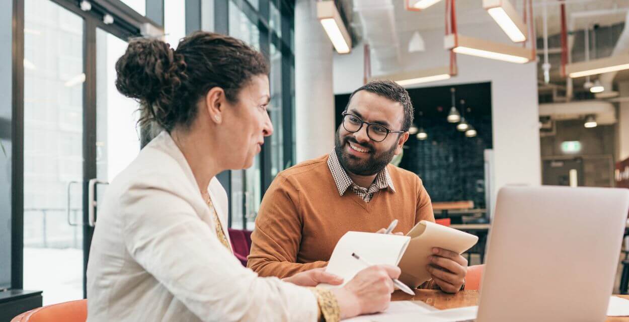 two-employees-discuss-work-blog